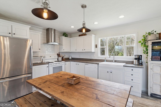 kitchen featuring white appliances, a sink, white cabinets, wall chimney exhaust hood, and backsplash