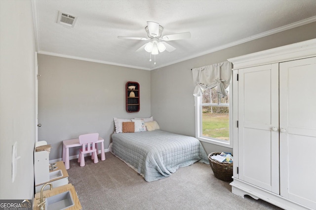 bedroom featuring visible vents, carpet floors, ornamental molding, and a ceiling fan