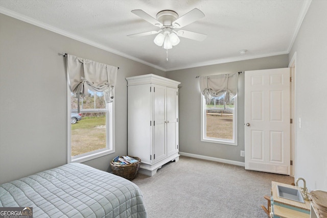 carpeted bedroom with baseboards, a textured ceiling, ornamental molding, and a ceiling fan