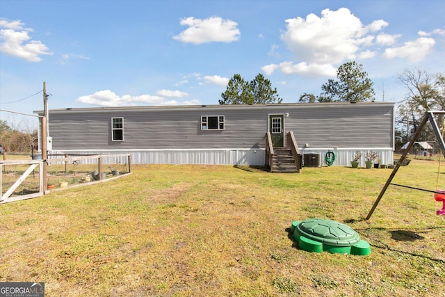 rear view of property featuring a yard and central AC