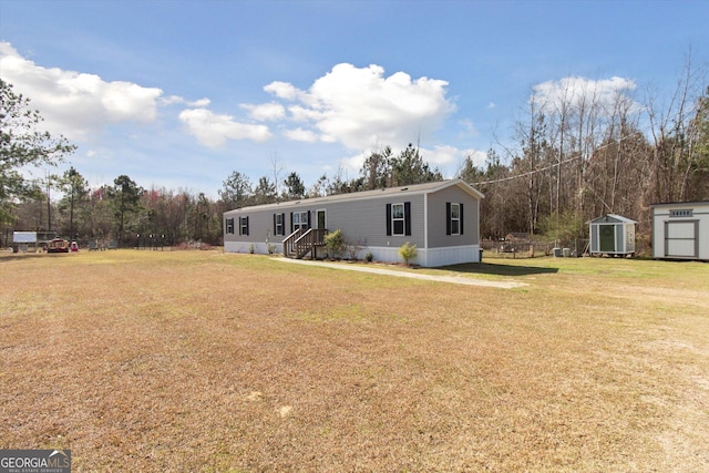 manufactured / mobile home featuring a shed, a front yard, and an outdoor structure