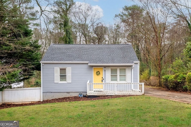 view of front of property featuring crawl space, covered porch, a shingled roof, and a front yard