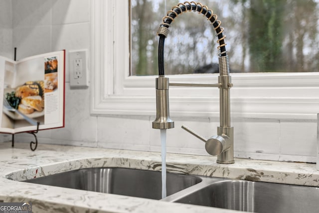 room details featuring light stone counters and a sink