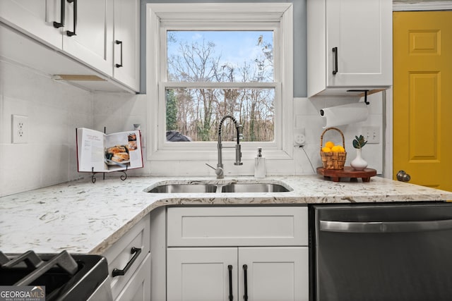 kitchen with a sink, tasteful backsplash, white cabinets, and stainless steel dishwasher