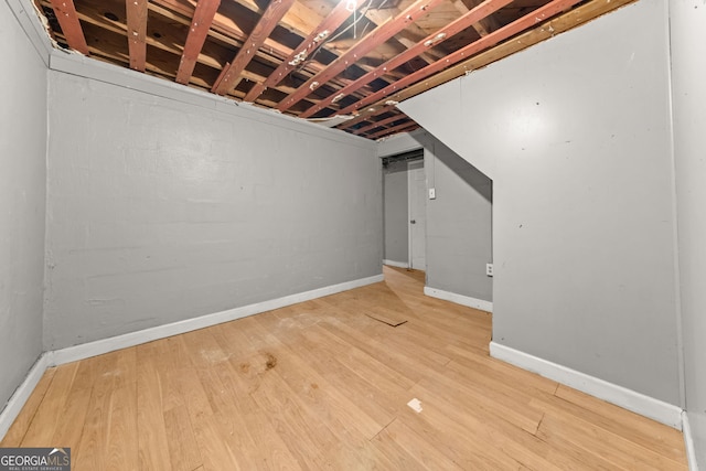 unfinished below grade area with baseboards and light wood-style floors