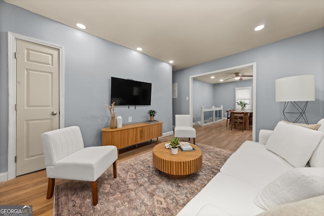 living area featuring baseboards, wood finished floors, and recessed lighting