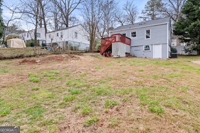 view of yard with stairs, central AC, fence, and a wooden deck