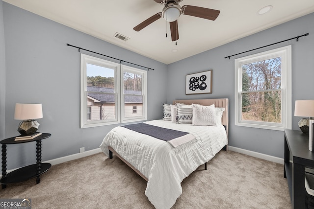 bedroom with visible vents, carpet flooring, and multiple windows