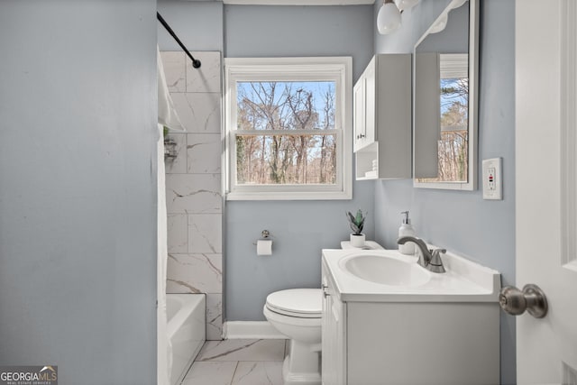 bathroom with marble finish floor, toilet, washtub / shower combination, vanity, and baseboards