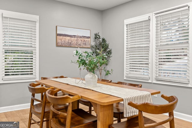 dining area with light wood-type flooring and baseboards