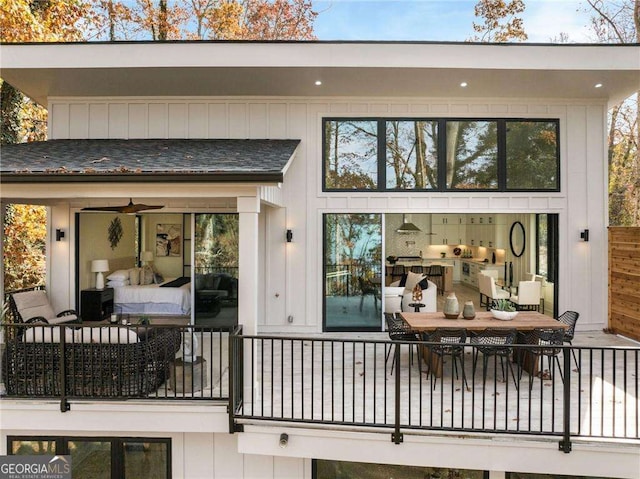 back of property featuring a ceiling fan, outdoor lounge area, and a shingled roof