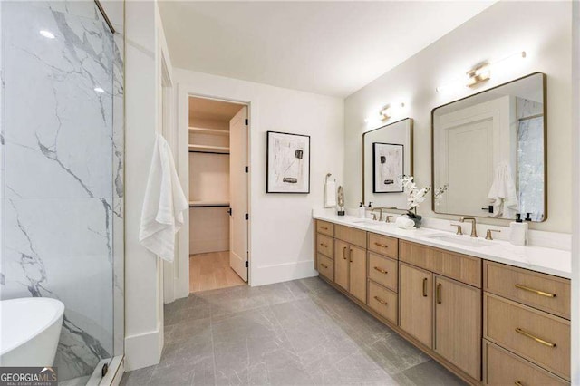 full bath with double vanity, a soaking tub, a sink, and a walk in closet