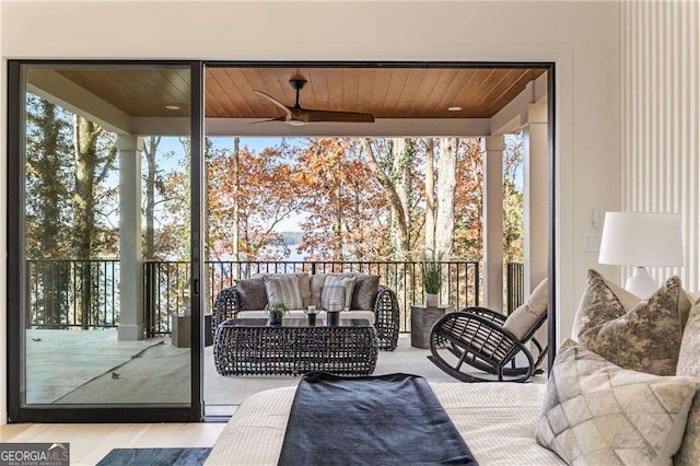 sunroom / solarium featuring wood ceiling, ceiling fan, and a wealth of natural light