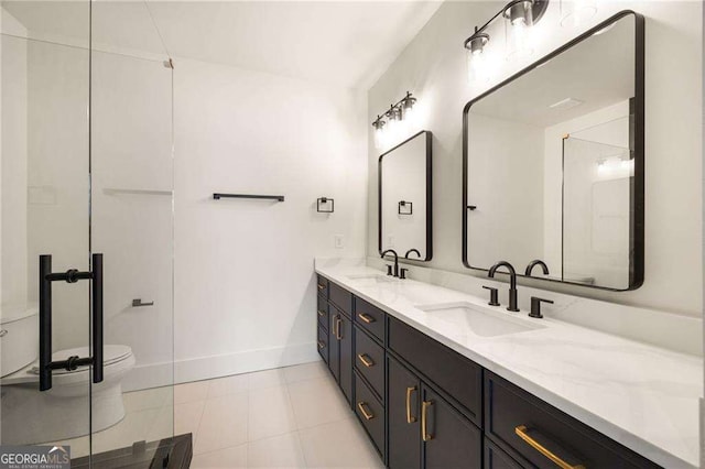 bathroom with double vanity, tile patterned flooring, toilet, and a sink