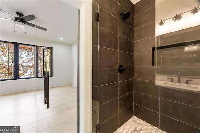 bathroom with a shower stall, a ceiling fan, and baseboards