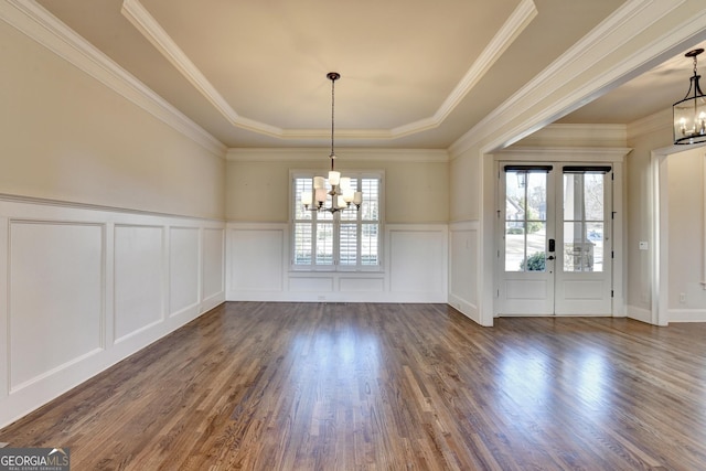 unfurnished dining area featuring plenty of natural light, wood finished floors, and an inviting chandelier