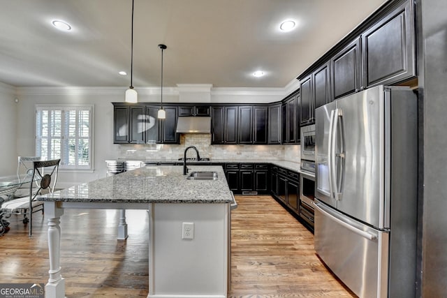 kitchen with tasteful backsplash, appliances with stainless steel finishes, crown molding, under cabinet range hood, and a sink