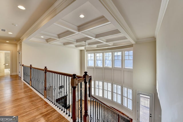 hall featuring coffered ceiling, wood finished floors, visible vents, ornamental molding, and beamed ceiling