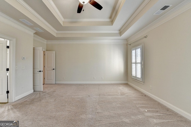 unfurnished room with carpet flooring, visible vents, baseboards, ornamental molding, and a raised ceiling