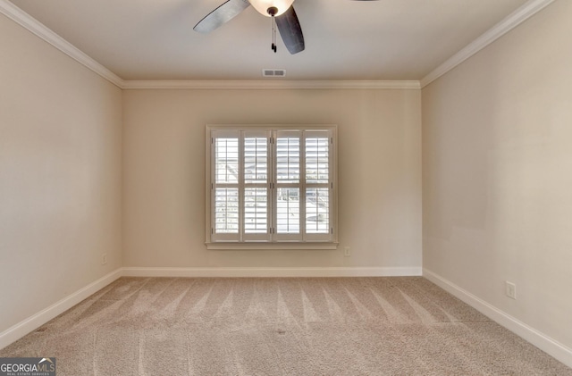 empty room featuring carpet, visible vents, baseboards, and ornamental molding