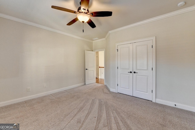 unfurnished bedroom with carpet floors, ornamental molding, and baseboards