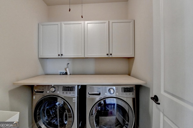 laundry area featuring washer and clothes dryer and cabinet space