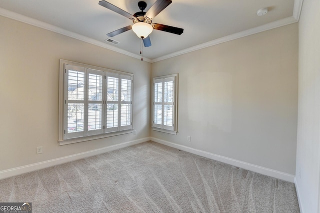 carpeted empty room featuring baseboards, visible vents, ceiling fan, and crown molding