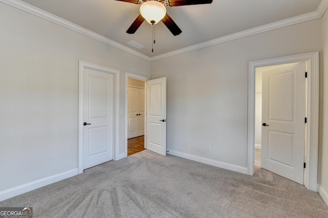 unfurnished bedroom featuring baseboards, carpet floors, visible vents, and crown molding