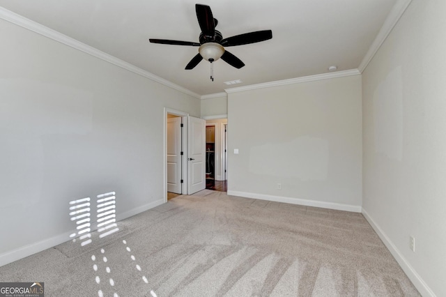 empty room with carpet floors, ornamental molding, visible vents, and baseboards