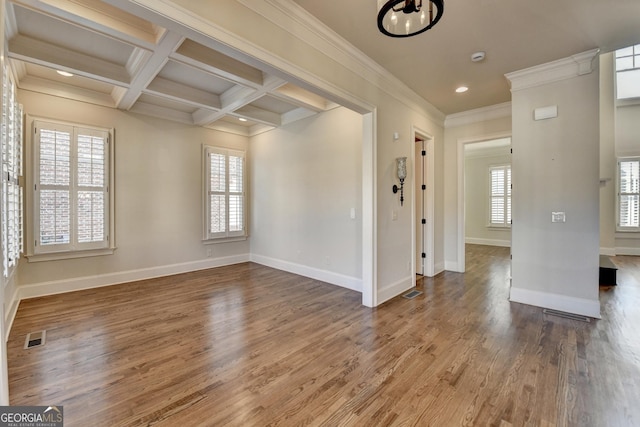 unfurnished room with coffered ceiling, wood finished floors, visible vents, and a healthy amount of sunlight