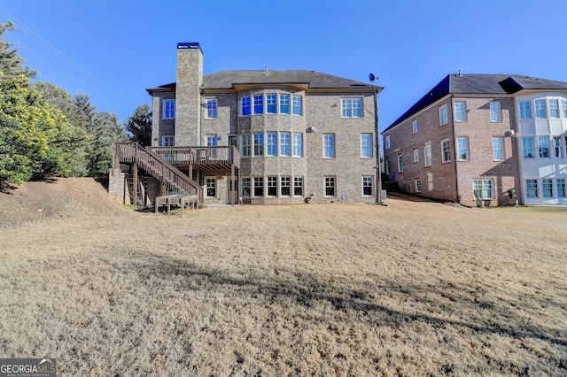 rear view of property featuring stairs, a deck, and a chimney