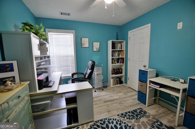 office space with light wood-type flooring, visible vents, and a ceiling fan