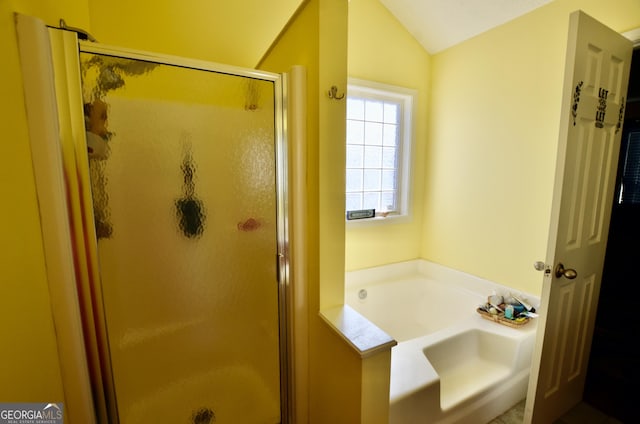 bathroom with lofted ceiling, a shower stall, and a bath