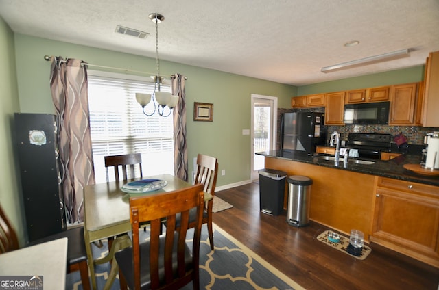 kitchen with a wealth of natural light, black appliances, tasteful backsplash, and visible vents