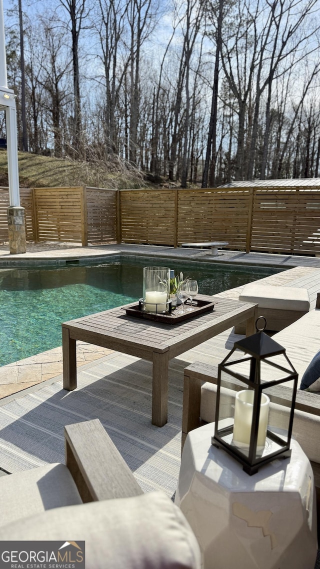 exterior space featuring a fenced backyard, a fenced in pool, outdoor dining area, and a patio