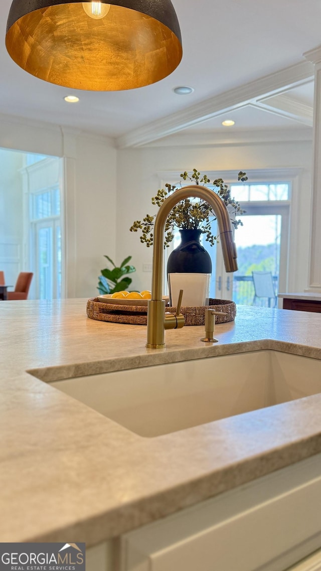 interior details featuring light countertops, a sink, crown molding, and recessed lighting