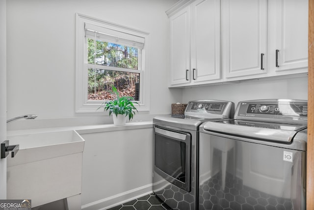 clothes washing area with cabinet space, a sink, and washer and clothes dryer