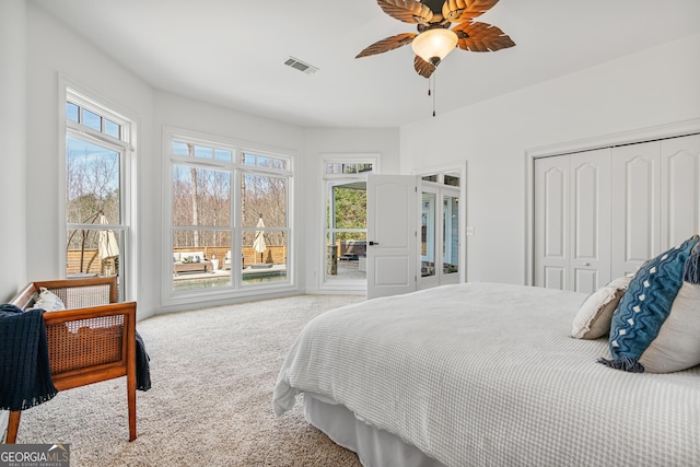 bedroom with a closet, carpet flooring, ceiling fan, and visible vents
