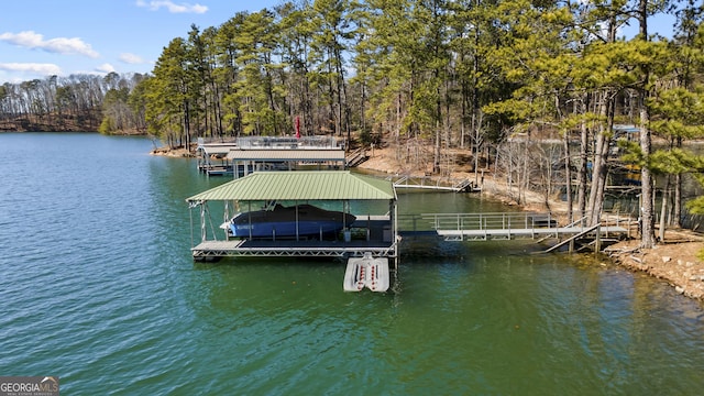 view of dock featuring a water view, a view of trees, and boat lift
