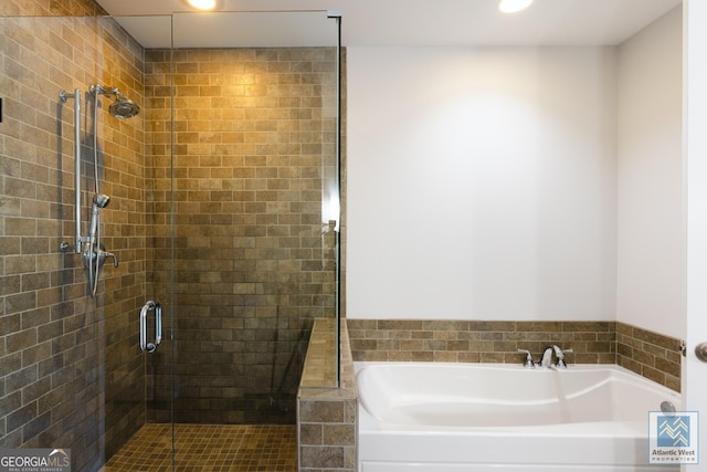 bathroom with a stall shower, recessed lighting, and a bath