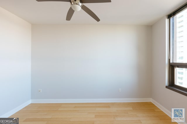 unfurnished room with baseboards, a healthy amount of sunlight, and light wood finished floors