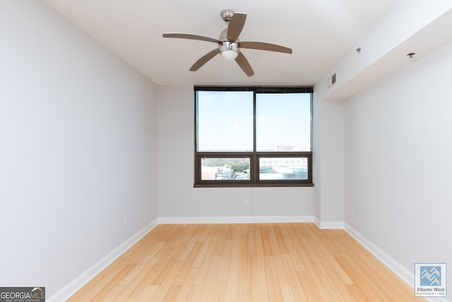 spare room featuring ceiling fan, wood finished floors, and baseboards