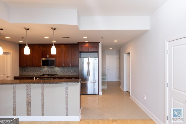 kitchen featuring visible vents, appliances with stainless steel finishes, decorative light fixtures, backsplash, and light tile patterned flooring