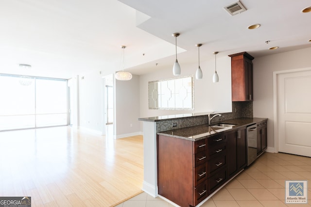 kitchen featuring a sink, visible vents, a healthy amount of sunlight, decorative backsplash, and dishwasher