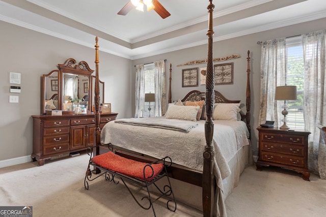 bedroom with baseboards, ornamental molding, a raised ceiling, and light colored carpet