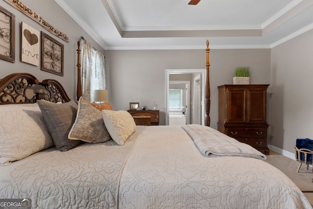 carpeted bedroom with a tray ceiling, crown molding, baseboards, and ceiling fan