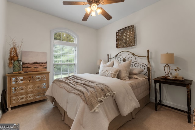 bedroom with light carpet and a ceiling fan