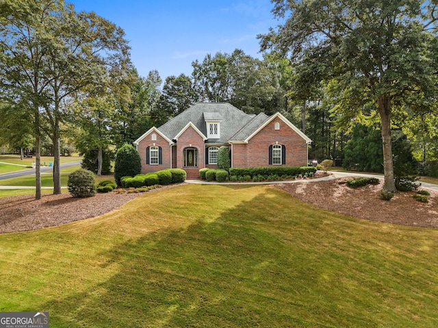 view of front of house featuring a front lawn and brick siding