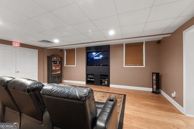 cinema featuring a paneled ceiling, recessed lighting, visible vents, light wood-type flooring, and baseboards