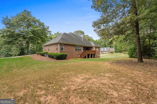 view of home's exterior featuring brick siding, a lawn, and stairs